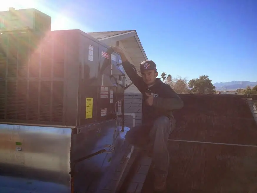 HVAC technician performing HVAC Inspection on a rooftop unit in Armada